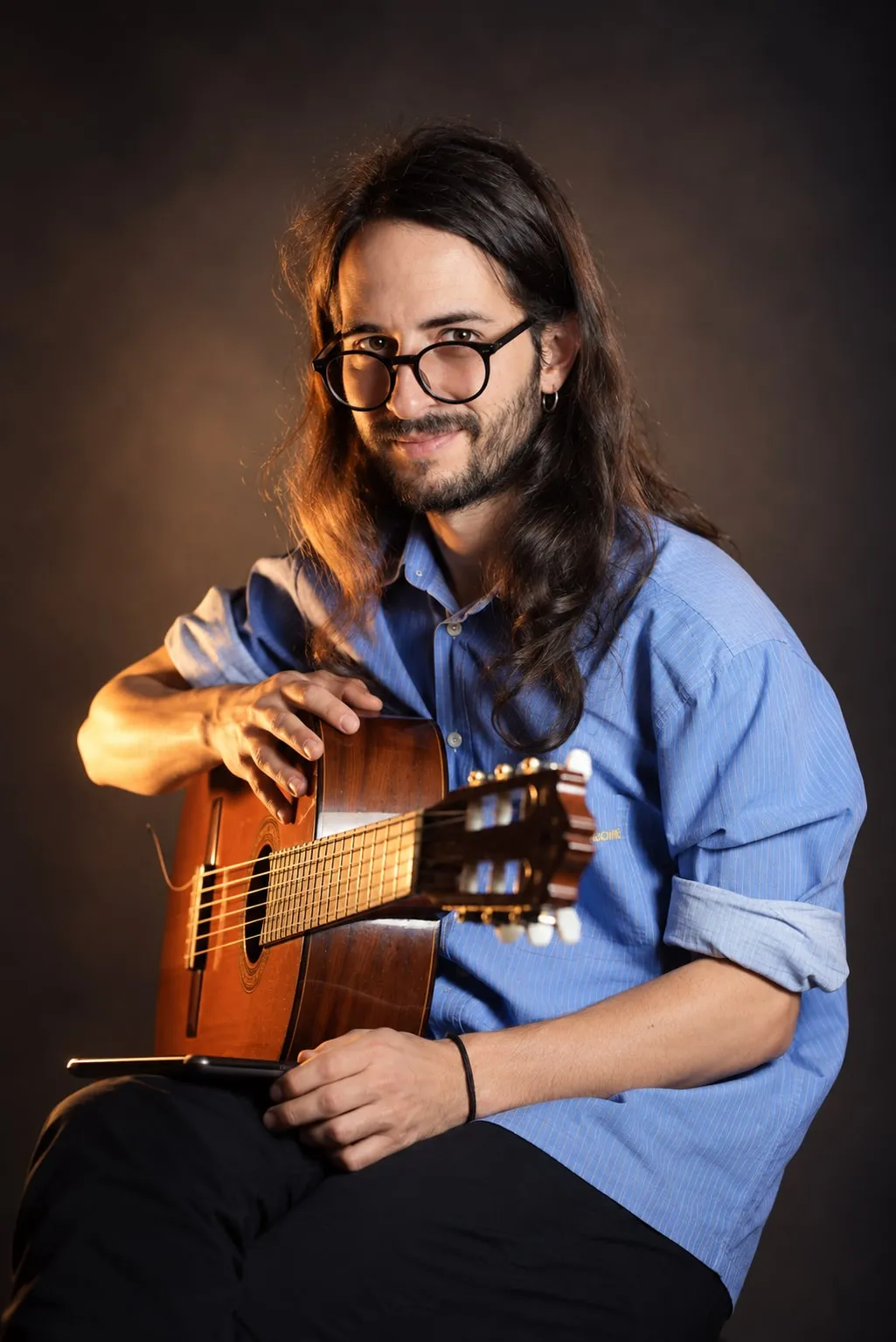 adris con la guitarra clásica, mirando a cámara