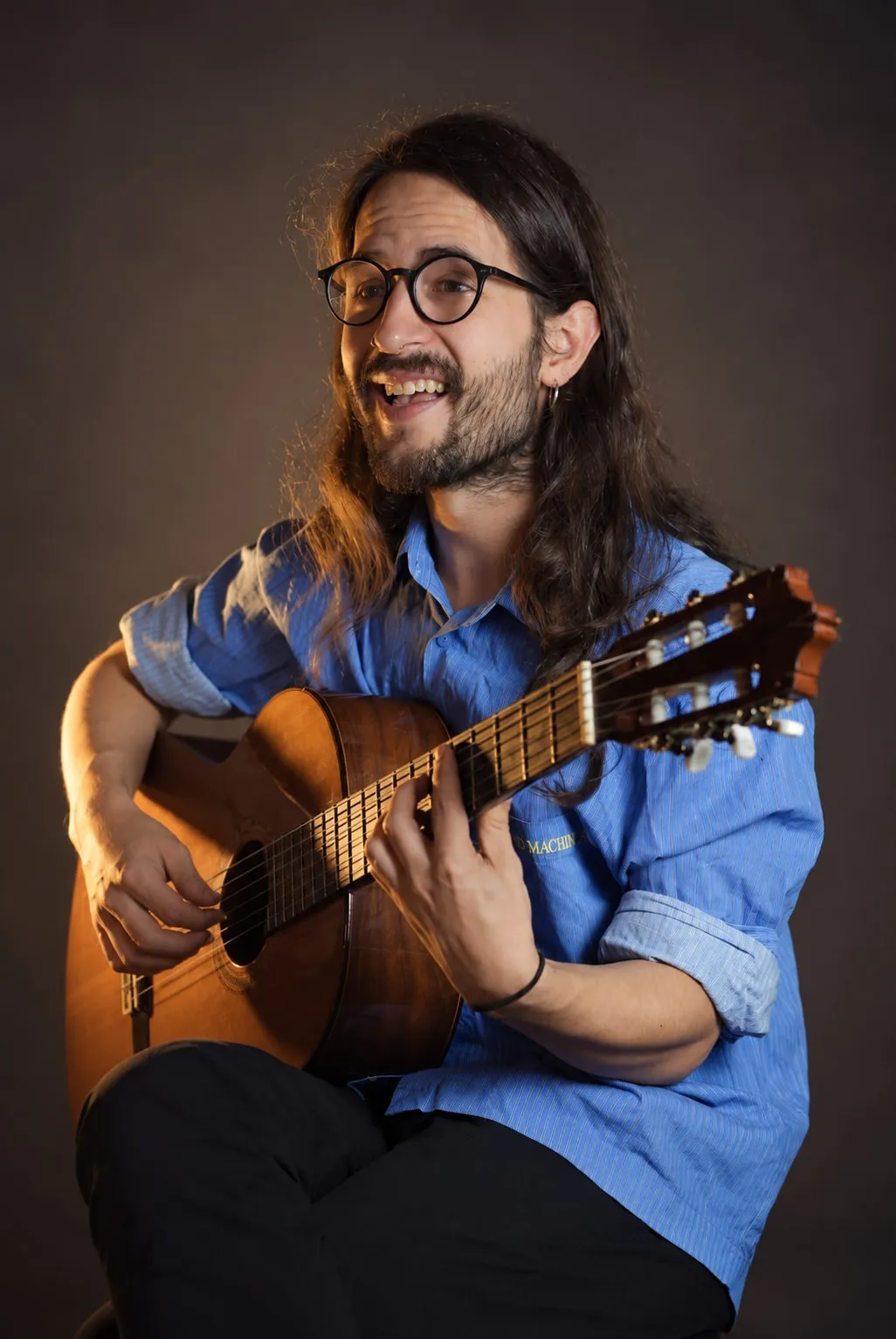 adris riendo mientras toca la guitarra clásica